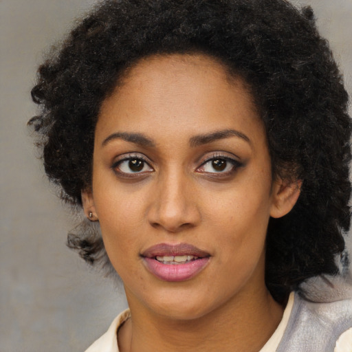 Joyful black young-adult female with medium  brown hair and brown eyes