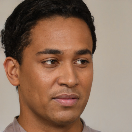 Joyful black young-adult male with short  brown hair and brown eyes
