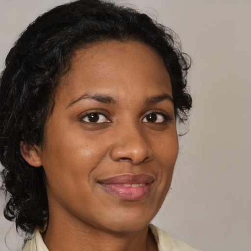 Joyful black adult female with medium  brown hair and brown eyes