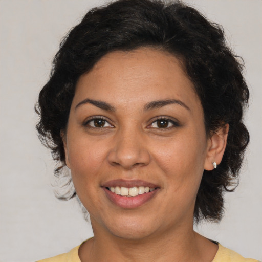 Joyful latino adult female with medium  brown hair and brown eyes