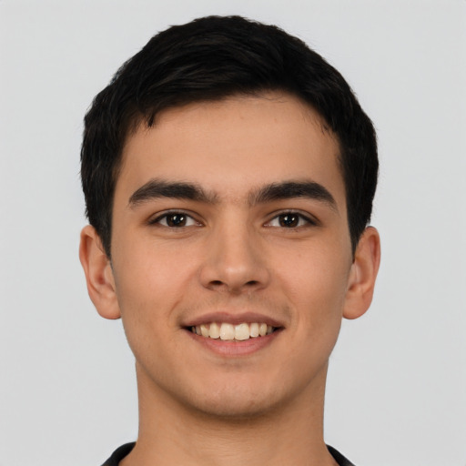 Joyful latino young-adult male with short  brown hair and brown eyes