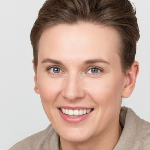 Joyful white young-adult female with short  brown hair and grey eyes