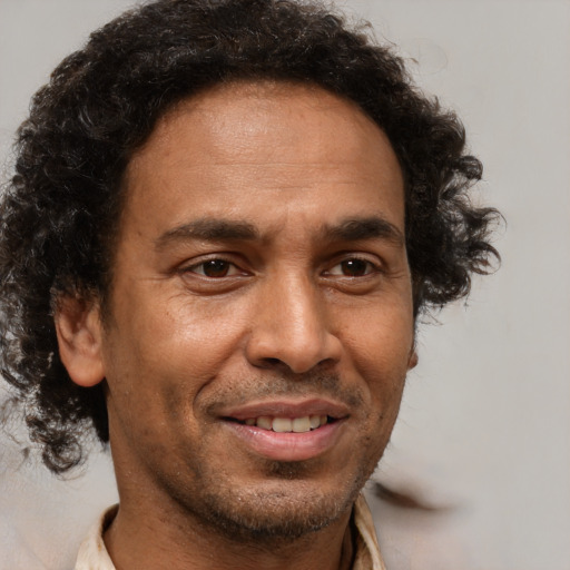 Joyful black adult male with short  brown hair and brown eyes