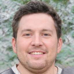 Joyful white adult male with short  brown hair and grey eyes