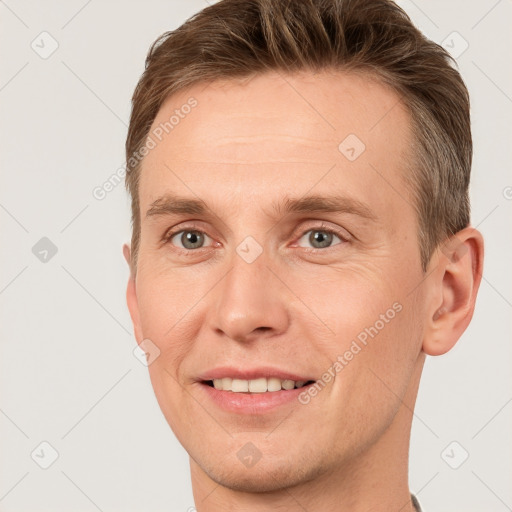 Joyful white adult male with short  brown hair and grey eyes