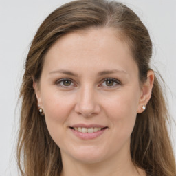 Joyful white young-adult female with long  brown hair and grey eyes