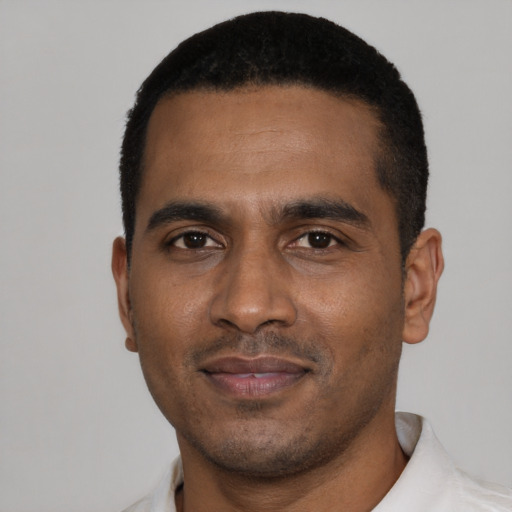 Joyful black young-adult male with short  black hair and brown eyes