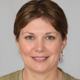 Joyful white young-adult female with medium  brown hair and grey eyes