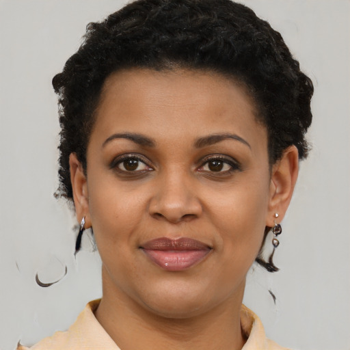 Joyful black young-adult female with short  brown hair and brown eyes