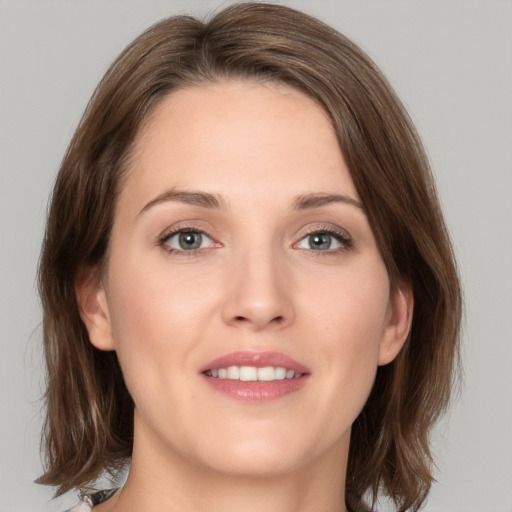 Joyful white young-adult female with medium  brown hair and green eyes