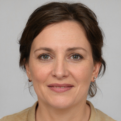 Joyful white adult female with medium  brown hair and grey eyes