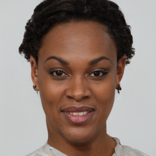 Joyful black young-adult female with short  brown hair and brown eyes