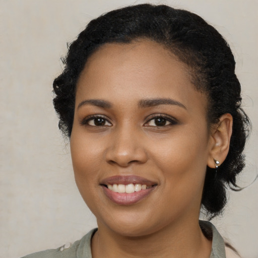 Joyful black young-adult female with long  black hair and brown eyes