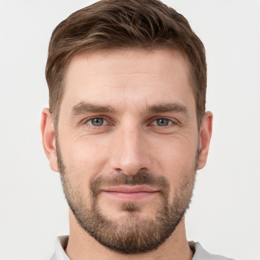 Joyful white young-adult male with short  brown hair and grey eyes