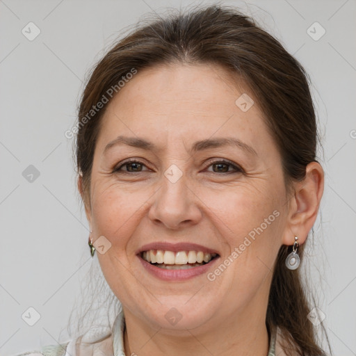 Joyful white adult female with medium  brown hair and grey eyes