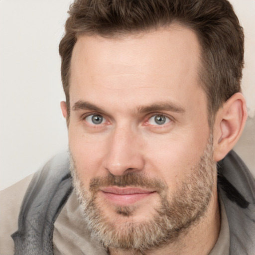 Joyful white adult male with short  brown hair and brown eyes