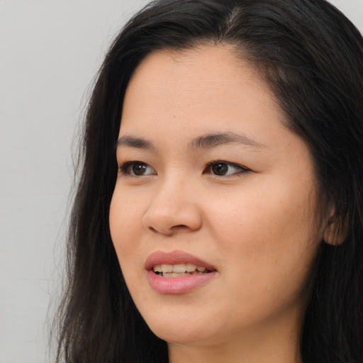Joyful asian young-adult female with long  brown hair and brown eyes