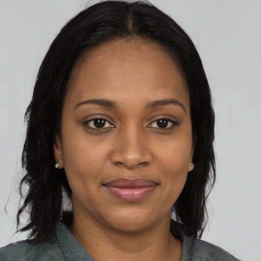 Joyful black young-adult female with long  brown hair and brown eyes
