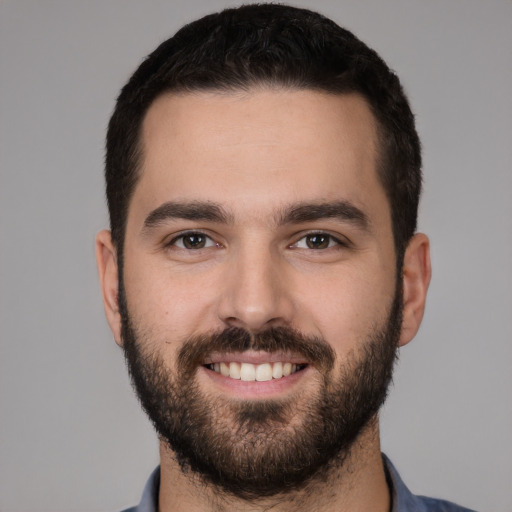 Joyful white young-adult male with short  black hair and brown eyes