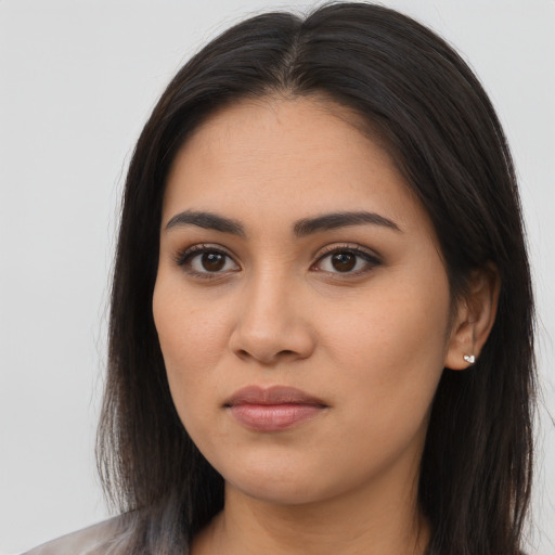 Joyful latino young-adult female with long  brown hair and brown eyes
