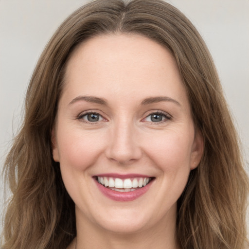 Joyful white young-adult female with long  brown hair and green eyes