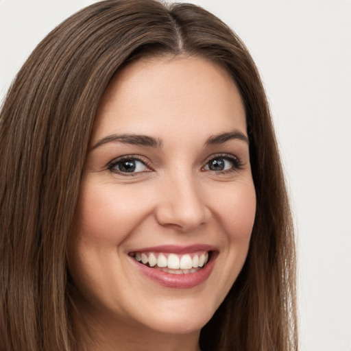 Joyful white young-adult female with long  brown hair and brown eyes