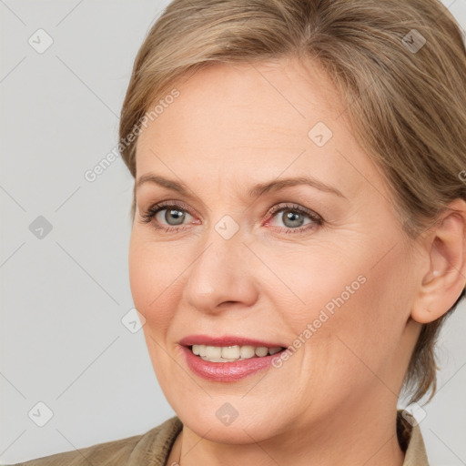 Joyful white adult female with medium  brown hair and blue eyes