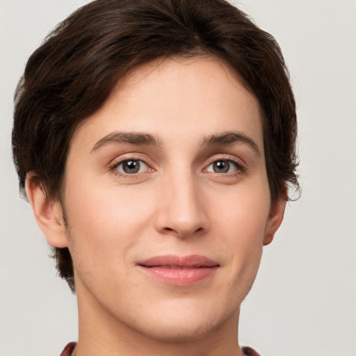 Joyful white young-adult female with short  brown hair and green eyes