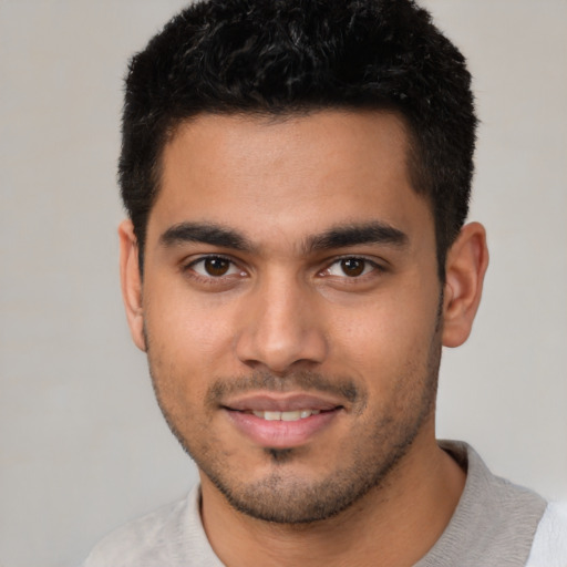 Joyful latino young-adult male with short  black hair and brown eyes