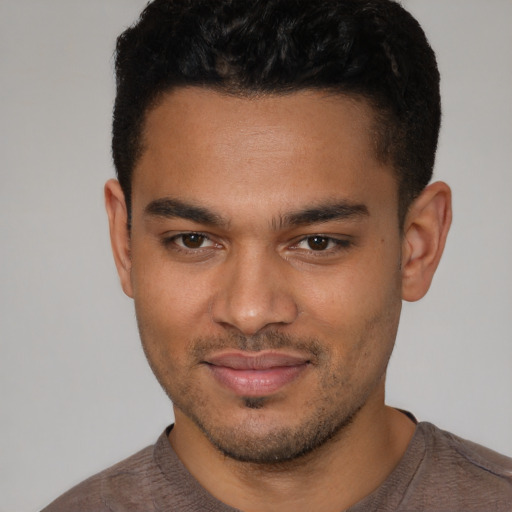 Joyful latino young-adult male with short  brown hair and brown eyes