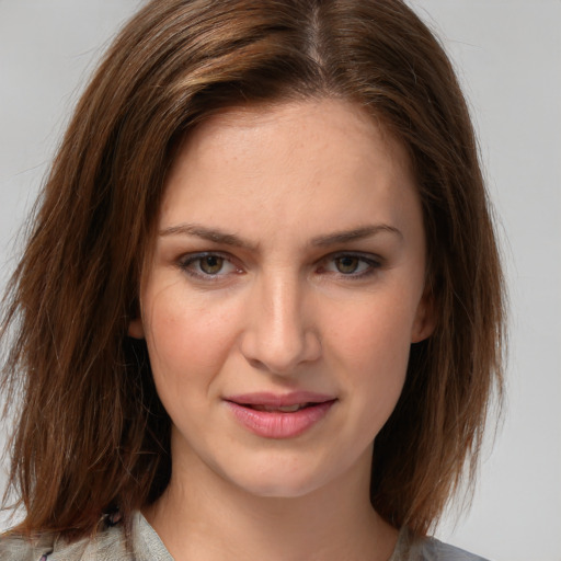 Joyful white young-adult female with medium  brown hair and grey eyes