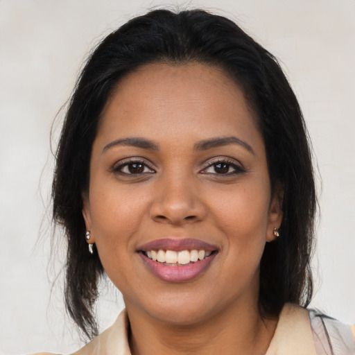 Joyful latino young-adult female with medium  brown hair and brown eyes