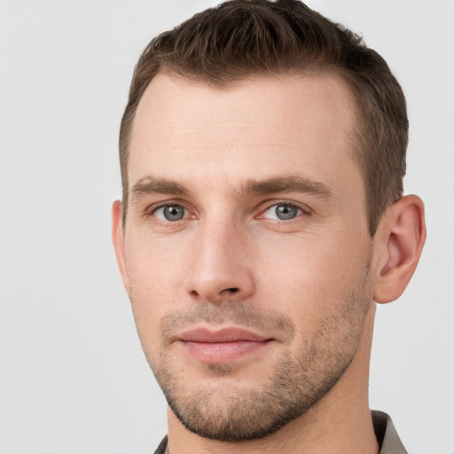 Joyful white young-adult male with short  brown hair and grey eyes