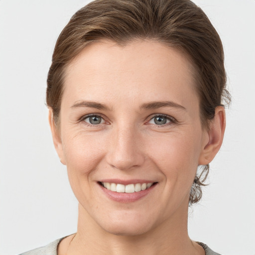 Joyful white young-adult female with short  brown hair and grey eyes