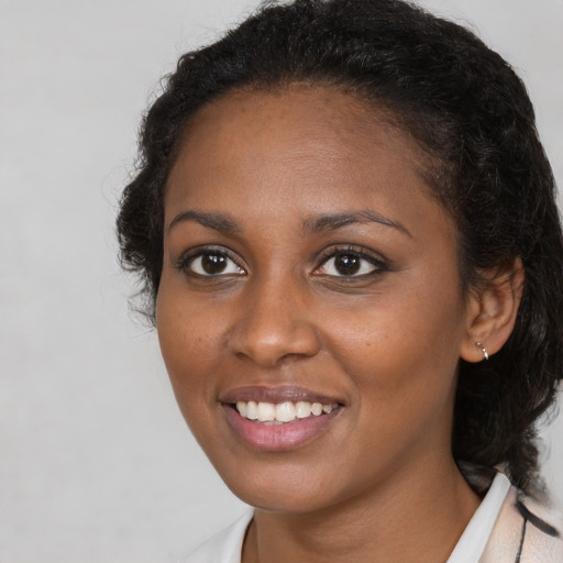 Joyful black young-adult female with medium  brown hair and brown eyes