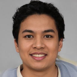 Joyful latino young-adult male with short  brown hair and brown eyes