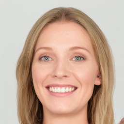 Joyful white young-adult female with long  brown hair and blue eyes