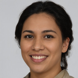 Joyful latino young-adult female with medium  brown hair and brown eyes