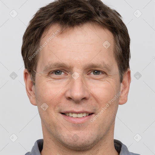 Joyful white adult male with short  brown hair and grey eyes