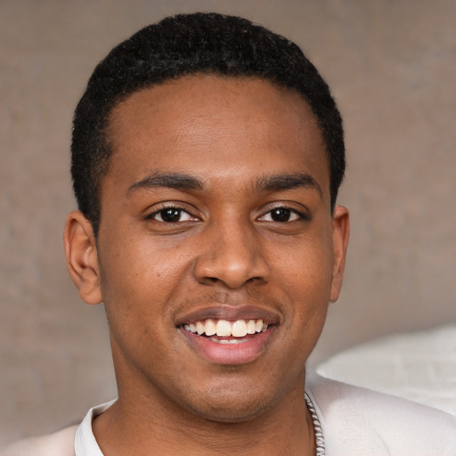 Joyful black young-adult male with short  black hair and brown eyes