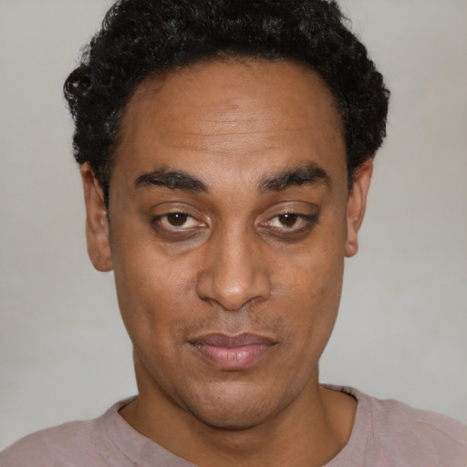 Joyful black adult male with short  black hair and brown eyes