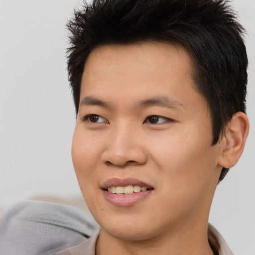 Joyful asian young-adult male with short  brown hair and brown eyes