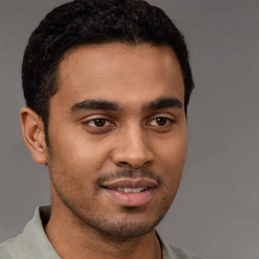 Joyful latino young-adult male with short  brown hair and brown eyes