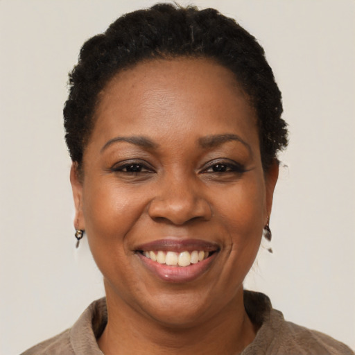 Joyful black adult female with short  black hair and brown eyes