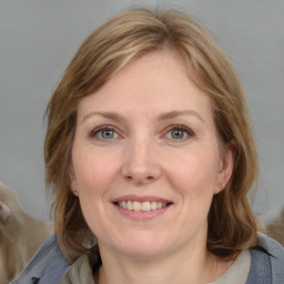 Joyful white adult female with medium  brown hair and blue eyes