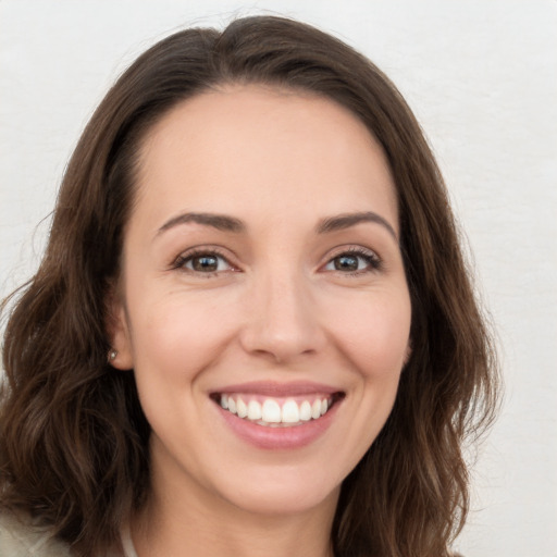 Joyful white young-adult female with long  brown hair and brown eyes