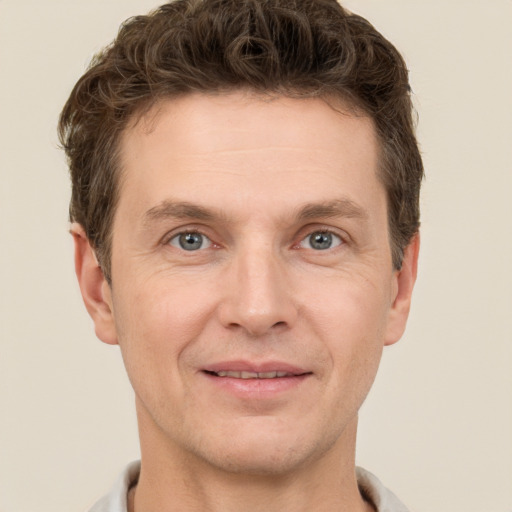 Joyful white adult male with short  brown hair and grey eyes