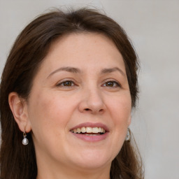 Joyful white adult female with long  brown hair and grey eyes