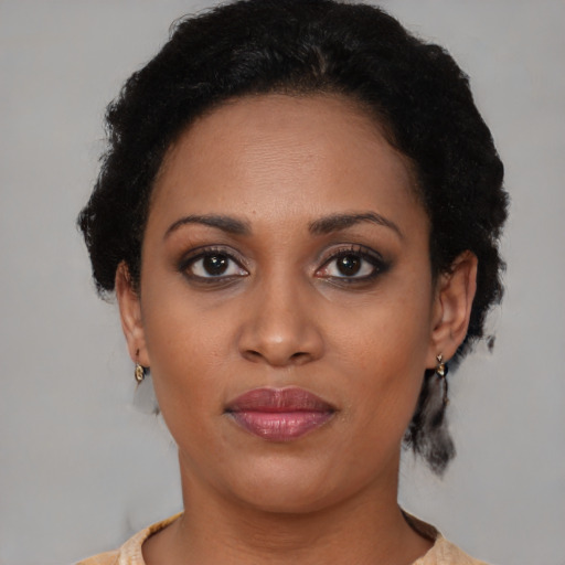 Joyful black young-adult female with short  brown hair and brown eyes