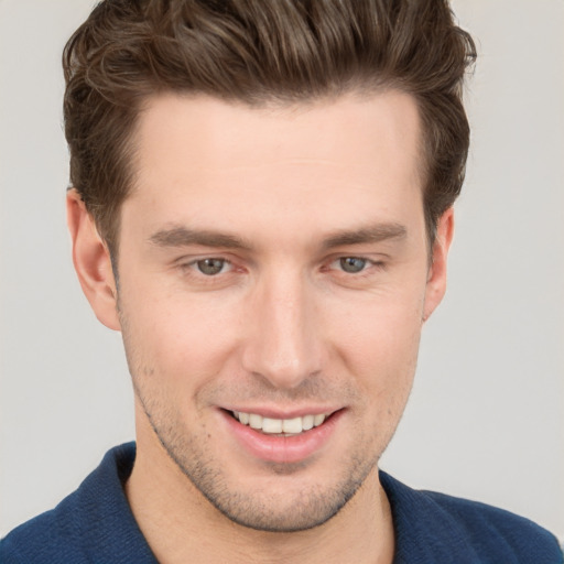 Joyful white young-adult male with short  brown hair and grey eyes